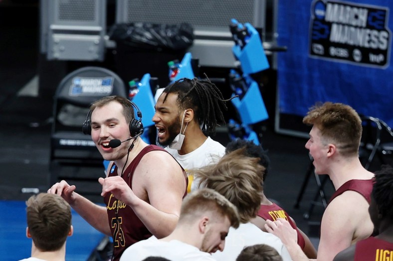 Mar 21, 2021; Indianapolis, Indiana, USA; The Loyola Ramblers swarm center Cameron Krutwig (25) while he is being interviews after their win over the Illinois Fighting Illini in the second round of the 2021 NCAA Tournament at Bankers Life Fieldhouse. The Loyola Ramblers won 71-58. Mandatory Credit: Trevor Ruszkowski-USA TODAY Sports