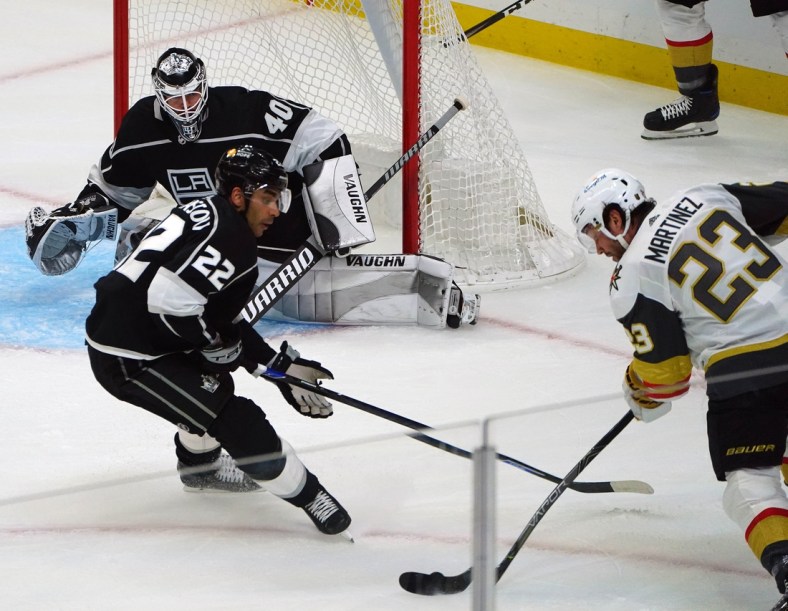 Mar 21, 2021; Los Angeles, California, USA; Vegas Golden Knights defenseman Alec Martinez (23) moves in for a shot as Los Angeles Kings left wing Andreas Athanasiou (22) helps goaltender Calvin Petersen (40) defend the goal during the first period at Staples Center. Mandatory Credit: Gary A. Vasquez-USA TODAY Sports
