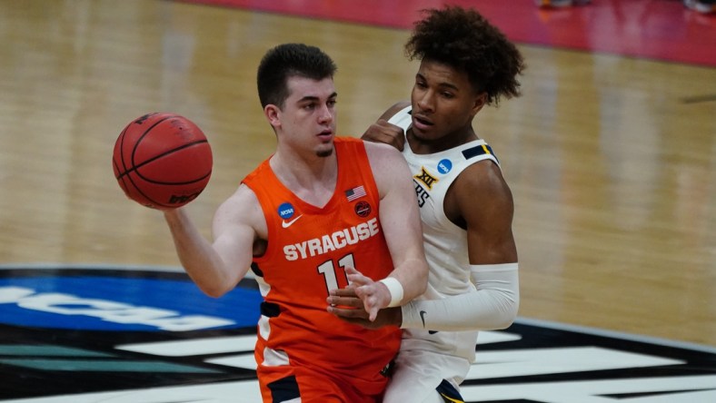 Mar 21, 2021; Indianapolis, Indiana, USA; Syracuse Orange guard Joseph Girard III (11) looks to move down court defended by West Virginia Mountaineers guard Miles McBride (4) in the second half in the second round of the 2021 NCAA Tournament at Bankers Life Fieldhouse. Mandatory Credit: Kirby Lee-USA TODAY Sports