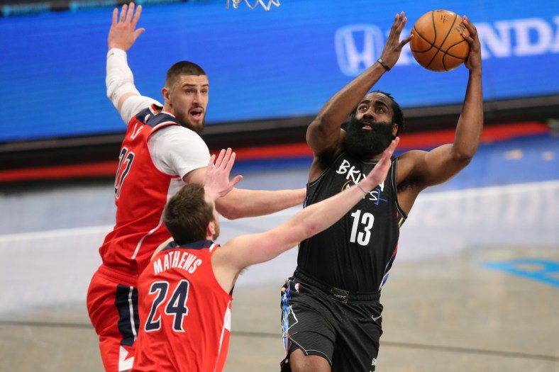 Mar 21, 2021; Brooklyn, New York, USA; Brooklyn Nets shooting guard James Harden (13) drives to the basket against Washington Wizards center Alex Len (27) and small forward Garrison Mathews (24) during the first quarter at Barclays Center. Mandatory Credit: Brad Penner-USA TODAY Sports