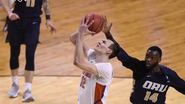 Mar 21, 2021; Indianapolis, Indiana, USA; Oral Roberts Golden Eagles forward DeShang Weaver (14) attempts to block a shot from Florida Gators forward Colin Castleton (12) in the second half in the second round of the 2021 NCAA Tournament at Indiana Farmers Coliseum. Mandatory Credit: Doug McSchooler-USA TODAY Sports