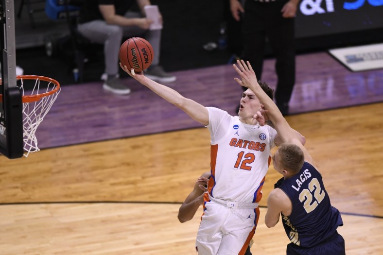 Mar 21, 2021; Indianapolis, IN, USA; Florida Gators forward Colin Castleton (12) attempts to got to the basket defended by Oral Roberts Golden Eagles forward Francis Lacis (22) in the second half at Indiana Farmers Coliseum. Mandatory Credit: Doug McSchooler-USA TODAY Sports