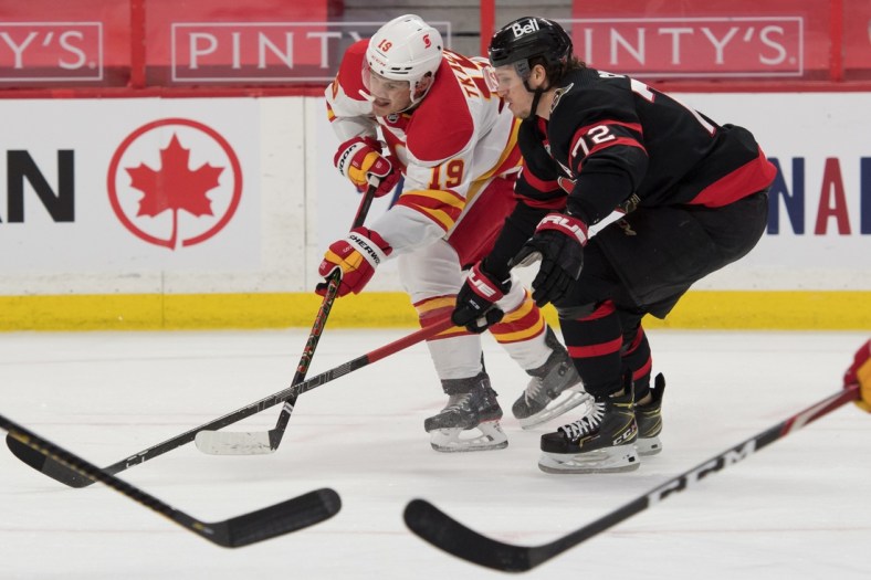 Mar 22, 2021; Ottawa, Ontario, CAN; Calgary Flames left wing Matthew Tkachuk (19) shoots the puck away from Ottawa Senators defenseman Thomas Chabot (72) in the first period at the Canadian Tire Centre. Mandatory Credit: Marc DesRosiers-USA TODAY Sports