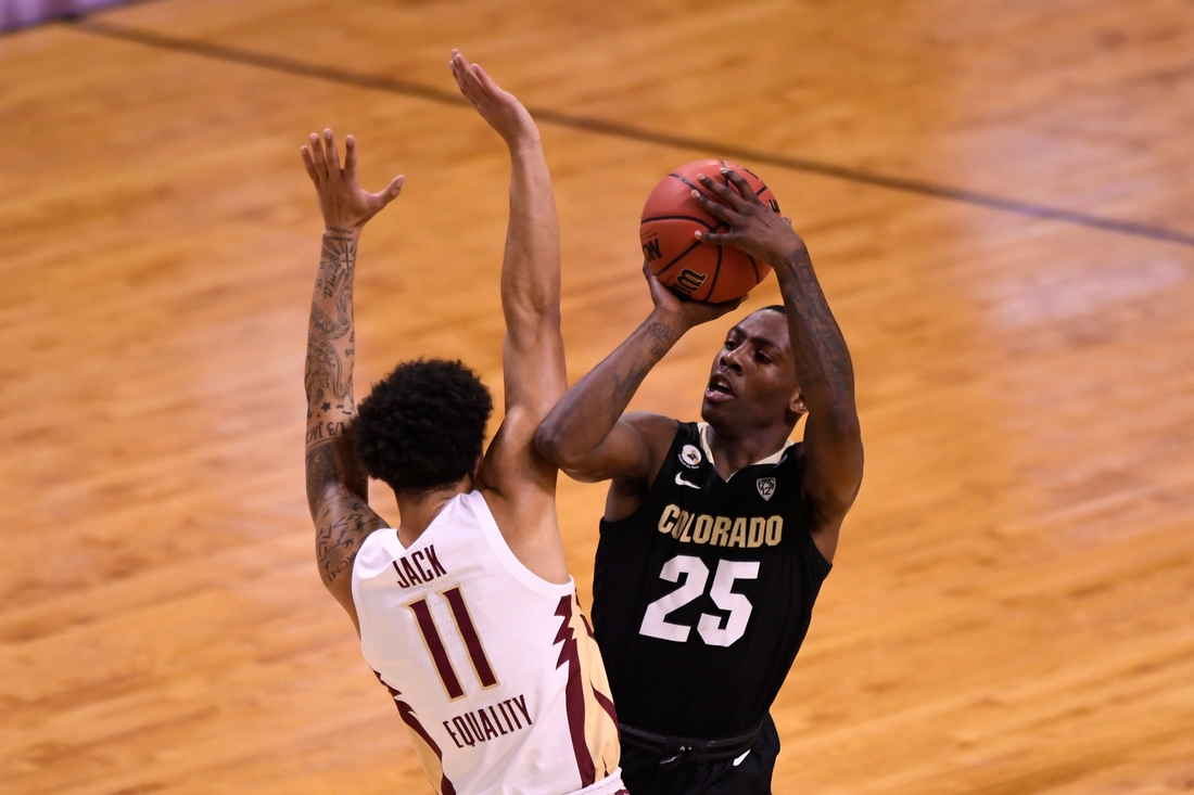 Mar 22, 2021; Indianapolis, Indiana, USA; Colorado Buffaloes guard McKinley Wright IV (25) makes contact with Florida State Seminoles guard Nathanael Jack (11) when attempting to shoot in the first half in the second round of the 2021 NCAA Tournament at Indiana Farmers Coliseum. Mandatory Credit: Doug McSchooler-USA TODAY Sports