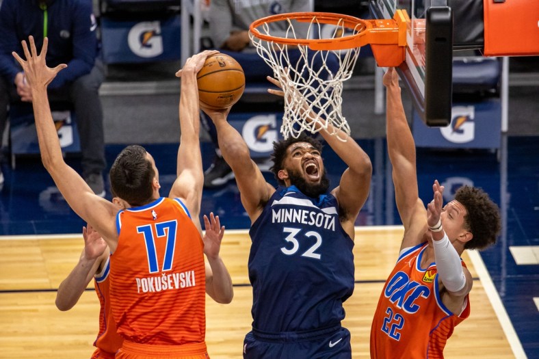 Mar 22, 2021; Minneapolis, Minnesota, USA; Minnesota Timberwolves center Karl-Anthony Towns (32) attempts to shoot the ball as Oklahoma City Thunder forward Aleksej Pokusevski (17) and center Isaiah Roby (22) play defense in the first half at Target Center. Mandatory Credit: Jesse Johnson-USA TODAY Sports