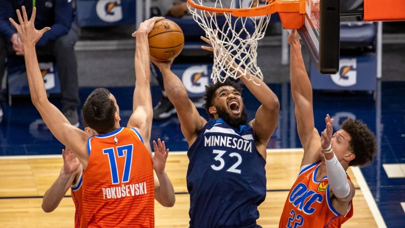 Mar 22, 2021; Minneapolis, Minnesota, USA; Minnesota Timberwolves center Karl-Anthony Towns (32) attempts to shoot the ball as Oklahoma City Thunder forward Aleksej Pokusevski (17) and center Isaiah Roby (22) play defense in the first half at Target Center. Mandatory Credit: Jesse Johnson-USA TODAY Sports