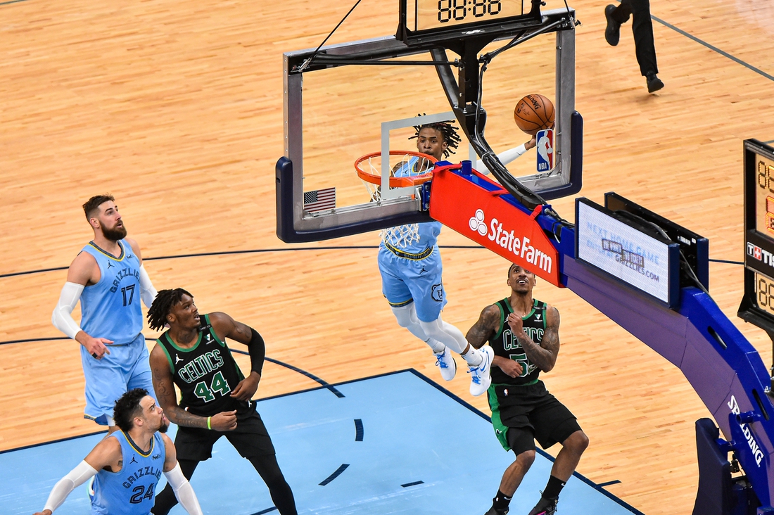 Mar 22, 2021; Memphis, Tennessee, USA; Memphis Grizzlies guard Ja Morant (12) dunks against Boston Celtics guard Jeff Teague (55) during the second half at FedExForum. Mandatory Credit: Justin Ford-USA TODAY Sports