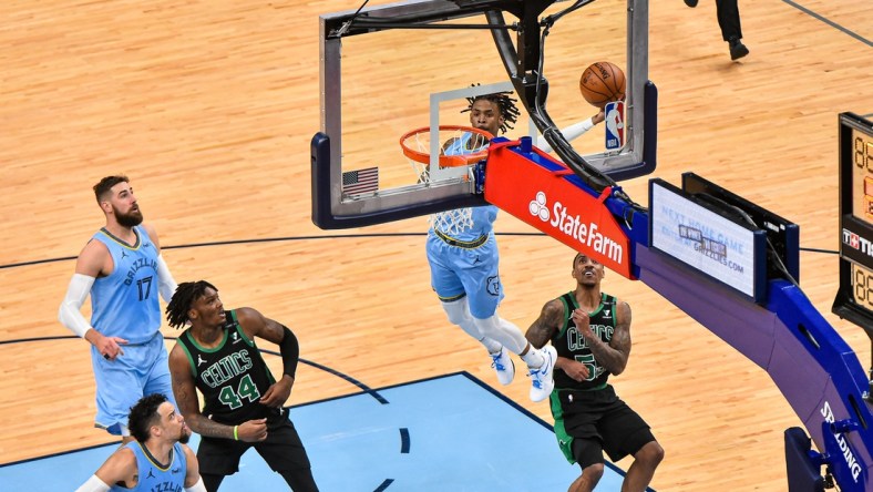 Mar 22, 2021; Memphis, Tennessee, USA; Memphis Grizzlies guard Ja Morant (12) dunks against Boston Celtics guard Jeff Teague (55) during the second half at FedExForum. Mandatory Credit: Justin Ford-USA TODAY Sports