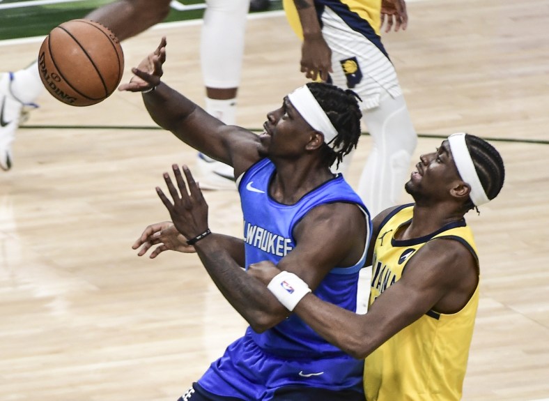 Mar 22, 2021; Milwaukee, Wisconsin, USA; Milwaukee Bucks guard Jrue Holiday is fouled by Indiana Pacers guard Caris LeVert (22) in the third quarter at Fiserv Forum. Mandatory Credit: Benny Sieu-USA TODAY Sports