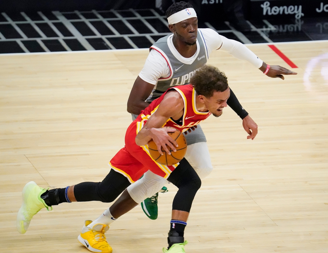 Mar 22, 2021; Los Angeles, California, USA; Atlanta Hawks guard Trae Young (11) dribbles the ball past LA Clippers guard Reggie Jackson (1) during the second quarter at Staples Center. Mandatory Credit: Robert Hanashiro-USA TODAY Sports