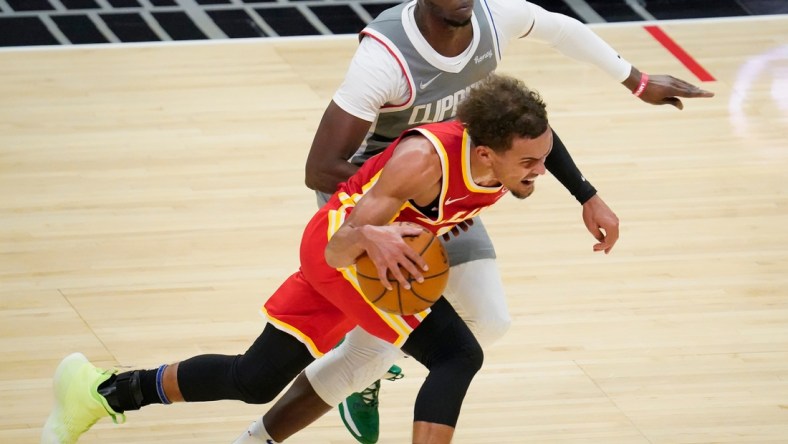 Mar 22, 2021; Los Angeles, California, USA; Atlanta Hawks guard Trae Young (11) dribbles the ball past LA Clippers guard Reggie Jackson (1) during the second quarter at Staples Center. Mandatory Credit: Robert Hanashiro-USA TODAY Sports