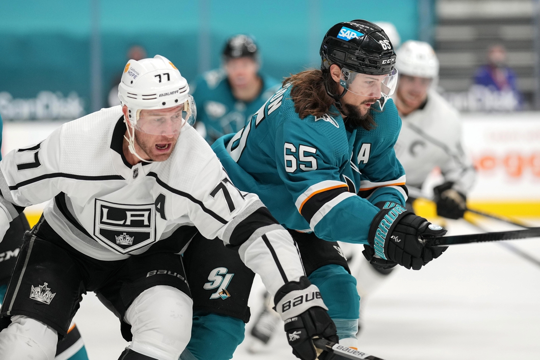 Mar 22, 2021; San Jose, California, USA;  Los Angeles Kings center Jeff Carter (77) and San Jose Sharks defenseman Erik Karlsson (65) chase after the puck during the first period at SAP Center at San Jose. Mandatory Credit: Stan Szeto-USA TODAY Sports