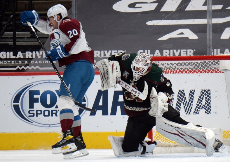 Mar 23, 2021; Glendale, Arizona, USA; Colorado Avalanche left wing Brandon Saad (20) is unable to deflect a shot past Arizona Coyotes goaltender Adin Hill (31) during the third period at Gila River Arena. Mandatory Credit: Joe Camporeale-USA TODAY Sports