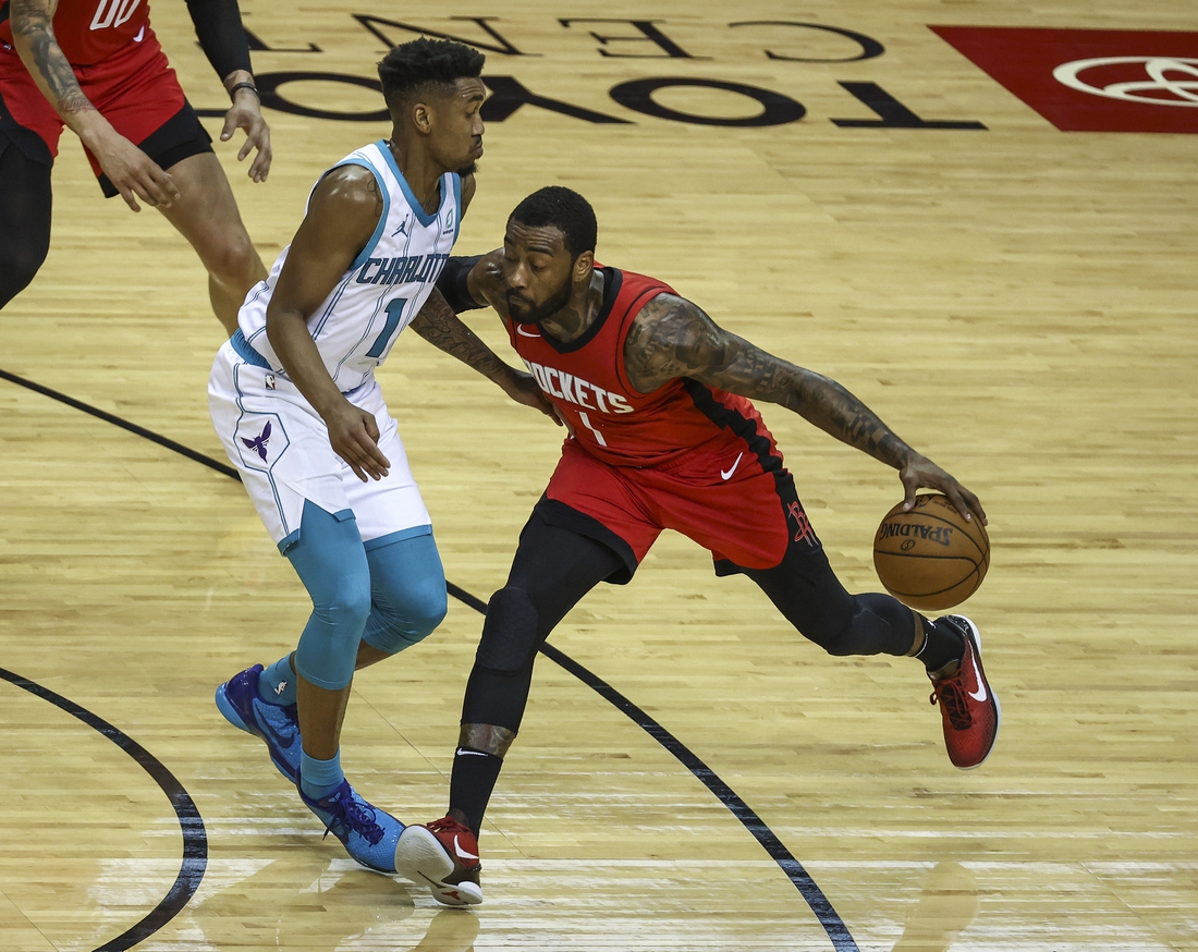 Mar 24, 2021; Houston, Texas, USA; Houston Rockets guard John Wall (1) dribbles the ball as Charlotte Hornets guard Malik Monk (1) defends during the fourth quarter at Toyota Center. Mandatory Credit: Troy Taormina-USA TODAY Sports