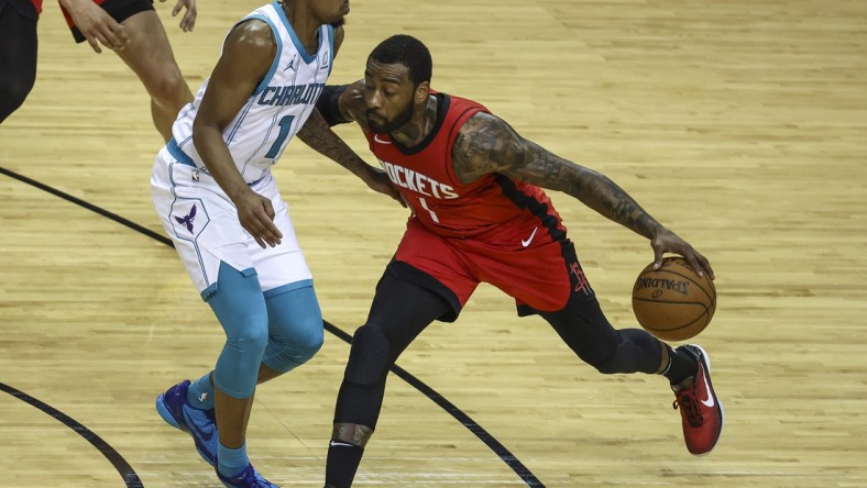 Mar 24, 2021; Houston, Texas, USA; Houston Rockets guard John Wall (1) dribbles the ball as Charlotte Hornets guard Malik Monk (1) defends during the fourth quarter at Toyota Center. Mandatory Credit: Troy Taormina-USA TODAY Sports