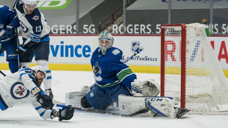 Mar 24, 2021; Vancouver, British Columbia, CAN; Vancouver Canucks goalie Thatcher Demko (35) makes a save on Winnipeg Jets forward Mathieu Perreault (85) in the first period at Rogers Arena. Mandatory Credit: Bob Frid-USA TODAY Sports