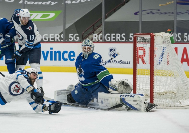 Mar 24, 2021; Vancouver, British Columbia, CAN; Vancouver Canucks goalie Thatcher Demko (35) makes a save on Winnipeg Jets forward Mathieu Perreault (85) in the first period at Rogers Arena. Mandatory Credit: Bob Frid-USA TODAY Sports