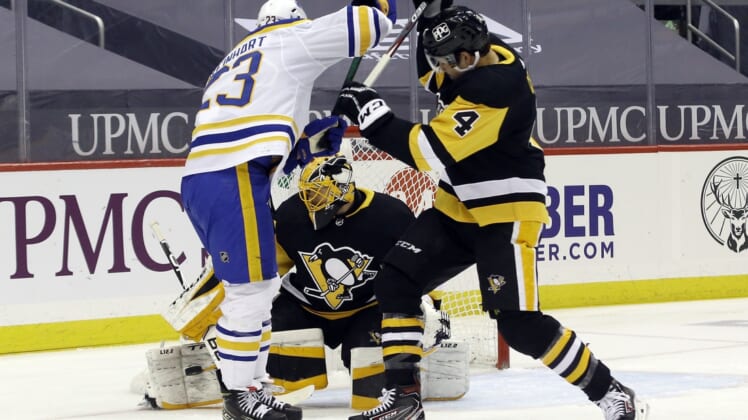 Mar 25, 2021; Pittsburgh, Pennsylvania, USA; Pittsburgh Penguins goaltender Casey DeSmith (1) makes a save as Pens defenseman Cody Ceci (4) battles Buffalo Sabres center Sam Reinhart (23) during the first period at PPG Paints Arena. Mandatory Credit: Charles LeClaire-USA TODAY Sports
