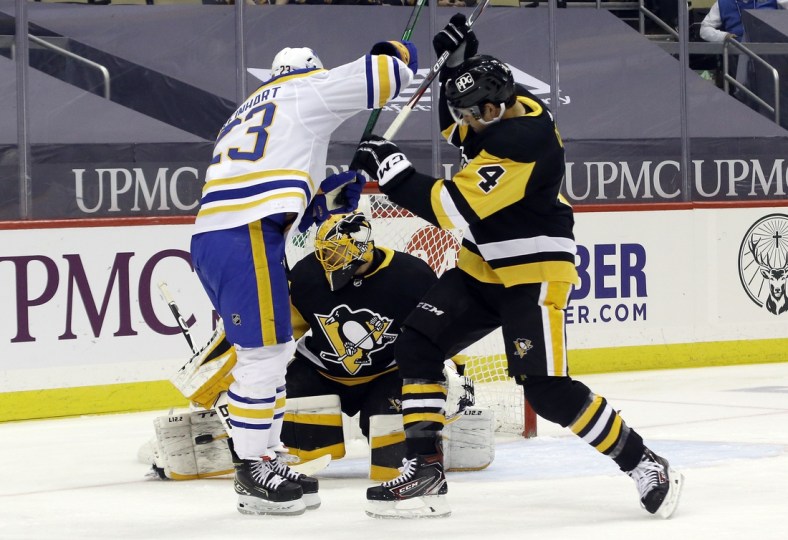 Mar 25, 2021; Pittsburgh, Pennsylvania, USA; Pittsburgh Penguins goaltender Casey DeSmith (1) makes a save as Pens defenseman Cody Ceci (4) battles Buffalo Sabres center Sam Reinhart (23) during the first period at PPG Paints Arena. Mandatory Credit: Charles LeClaire-USA TODAY Sports