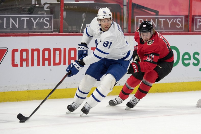 Mar 25, 2021; Ottawa, Ontario, CAN; Toronto Maple Leafs center John Tavares (91) skates with the puck in front of  Ottawa Senators left wing Ryan Dzingel (10) in the first period at the Canadian Tire Centre. Mandatory Credit: Marc DesRosiers-USA TODAY Sports