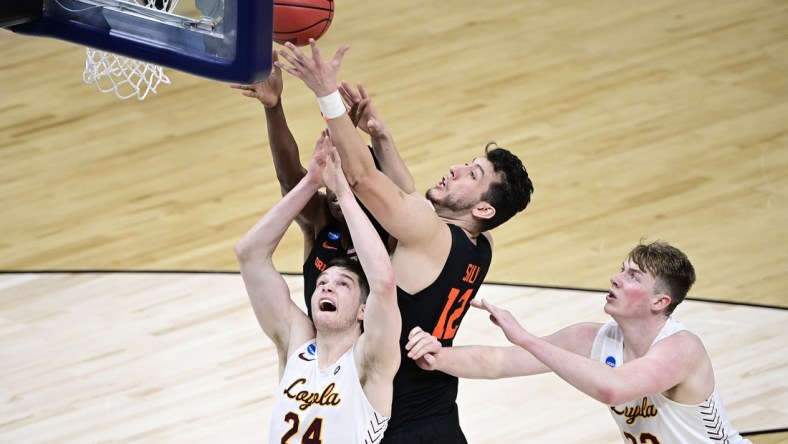 Mar 27, 2021; Indianapolis, IN, USA; Oregon State Beavers center Roman Silva (12) battles for a rebound against Loyola-Chicago Ramblers guard Tate Hall (24) and center Jacob Hutson (22) in the first half during the Sweet 16 of the 2021 NCAA Tournament at Bankers Life Fieldhouse.  Mandatory Credit: Marc Lebryk-USA TODAY Sports