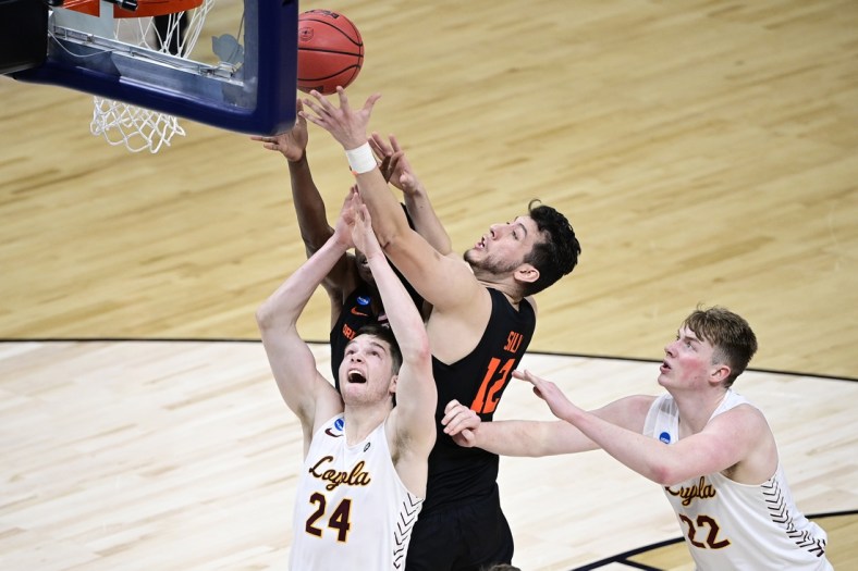 Mar 27, 2021; Indianapolis, IN, USA; Oregon State Beavers center Roman Silva (12) battles for a rebound against Loyola-Chicago Ramblers guard Tate Hall (24) and center Jacob Hutson (22) in the first half during the Sweet 16 of the 2021 NCAA Tournament at Bankers Life Fieldhouse.  Mandatory Credit: Marc Lebryk-USA TODAY Sports