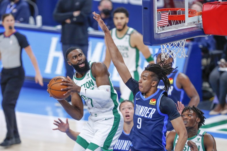 Mar 27, 2021; Oklahoma City, Oklahoma, USA; Boston Celtics guard Jaylen Brown (7) works to shoot as he is defended by Oklahoma City Thunder center Moses Brown (9) during the first quarter at Chesapeake Energy Arena. Mandatory Credit: Alonzo Adams-USA TODAY Sports