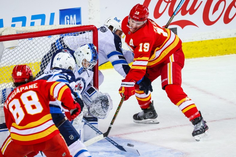 Mar 27, 2021; Calgary, Alberta, CAN; Calgary Flames left wing Matthew Tkachuk (19) moves in for a shot against Winnipeg Jets goaltender Laurent Brossoit (30) during the first period at Scotiabank Saddledome. Mandatory Credit: Sergei Belski-USA TODAY Sports