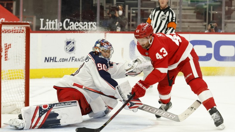 Mar 28, 2021; Detroit, Michigan, USA;  Detroit Red Wings left wing Darren Helm (43) shoots the puck on Columbus Blue Jackets goaltender Elvis Merzlikins (90) in the second period at Little Caesars Arena. Mandatory Credit: Rick Osentoski-USA TODAY Sports