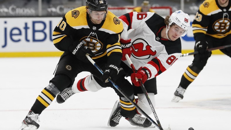 Mar 28, 2021; Boston, Massachusetts, USA; Boston Bruins left wing Anders Bjork (10) battles New Jersey Devils center Jack Hughes (86) for the puck during the first period at TD Garden. Mandatory Credit: Winslow Townson-USA TODAY Sports