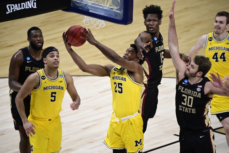 Mar 28, 2021; Indianapolis, IN, USA; Michigan Wolverines guard Jace Howard (25) shoots the ball against Florida State Seminoles center Quincy Ballard (15) and forward Harrison Prieto (30) in the second half during the Sweet 16 of the 2021 NCAA Tournament at Bankers Life Fieldhouse. Mandatory Credit: Marc Lebryk-USA TODAY Sports