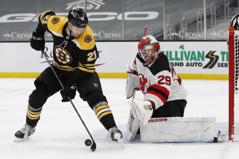 Mar 28, 2021; Boston, Massachusetts, USA; Boston Bruins left wing Nick Ritchie (21) deflects a shot in front of New Jersey Devils goaltender Mackenzie Blackwood (29) during the third period at TD Garden. Mandatory Credit: Winslow Townson-USA TODAY Sports