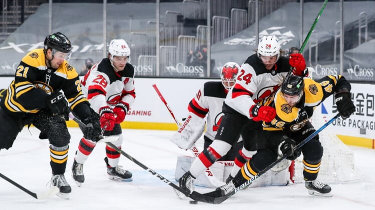 Mar 30, 2021; Boston, Massachusetts, USA; Boston Bruins left wing Nick Ritchie (21) and center David Krejci (46) and New Jersey Devils defenseman Ty Smith (24) battle for the puck during the first period at TD Garden. Mandatory Credit: Paul Rutherford-USA TODAY Sports