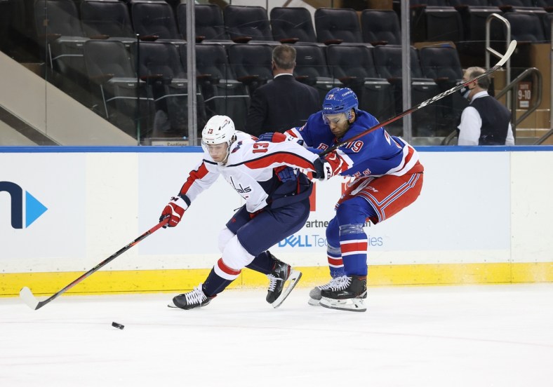 Mar 30, 2021; New York, New York, USA; Washington Capitals left wing Jakub Vrana (13) and New York Rangers defenseman K'Andre Miller (79) battle for the puck during a game at Madison Square Garden. Mandatory Credit: Al Bello/POOL PHOTOS-USA TODAY Sports