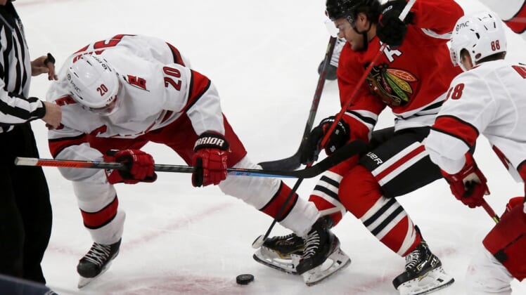Mar 30, 2021; Chicago, Illinois, USA; Carolina Hurricanes center Sebastian Aho (20) battles for the puck with Chicago Blackhawks Alex DeBrincat (12) during the first period at United Center. Mandatory Credit: Eileen T. Meslar-USA TODAY Sports