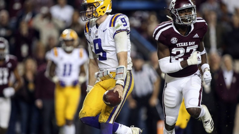 Nov 24, 2018; College Station, TX, USA; LSU Tigers quarterback Joe Burrow (9) runs for a touchdown as Texas A&M Aggies defensive back Roney Elam (27) defends during the seventh overtime at Kyle Field. Mandatory Credit: Troy Taormina-USA TODAY Sports