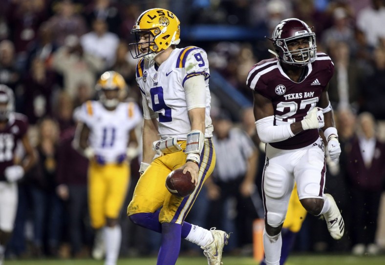 Nov 24, 2018; College Station, TX, USA; LSU Tigers quarterback Joe Burrow (9) runs for a touchdown as Texas A&M Aggies defensive back Roney Elam (27) defends during the seventh overtime at Kyle Field. Mandatory Credit: Troy Taormina-USA TODAY Sports