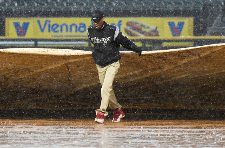 May 27, 2019; Chicago, IL, USA; A member of the grounds crew helps put a tarp on the field in a rain delay during the fifth inning of a game between the Chicago White Sox and the Kansas City Royals at Guaranteed Rate Field. Mandatory Credit: David Banks-USA TODAY Sports