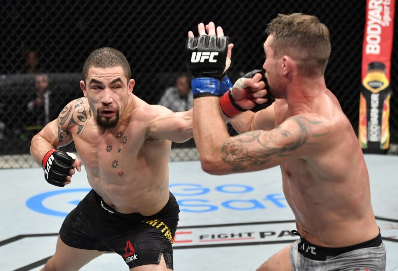 July 26, 2020; Abu Dhabi, UAE; Robert Whittaker (red gloves) of New Zealand punches Darren Till (blue gloves) of England in their middleweight fight during the UFC Fight Night event inside Flash Forum on UFC Fight Island.  Mandatory Credit: Jeff Bottari/Zuffa LLC via USA TODAY Sports