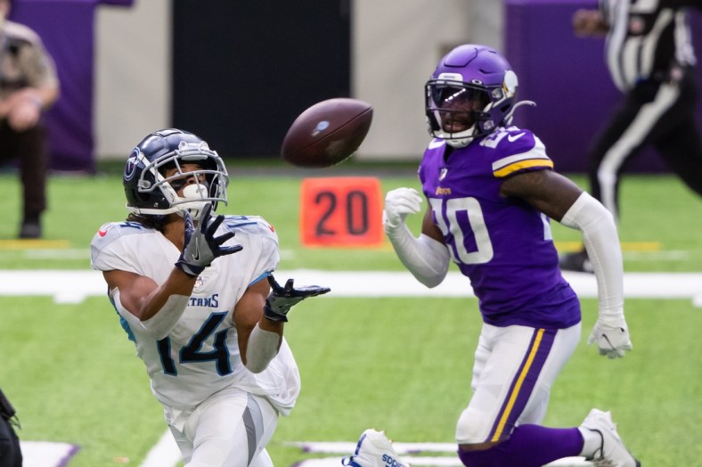 Sep 27, 2020; Minneapolis, Minnesota, USA; Tennessee Titans wide receiver Kalif Raymond (14) catches a pass in the third quarter against the Minnesota Vikings defensive back Jeff Gladney (20) at U.S. Bank Stadium. Mandatory Credit: Brad Rempel-USA TODAY Sports
