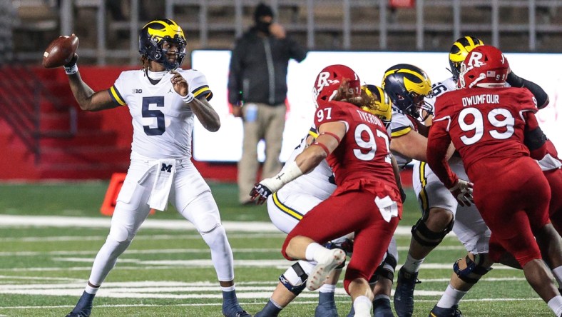 Nov 21, 2020; Piscataway, New Jersey, USA; Michigan Wolverines quarterback Joe Milton (5) throws the ball against Rutgers Scarlet Knights defensive lineman Mike Tverdov (97) and defensive lineman Michael Dwumfour (99) during the first half at SHI Stadium. Mandatory Credit: Vincent Carchietta-USA TODAY Sports