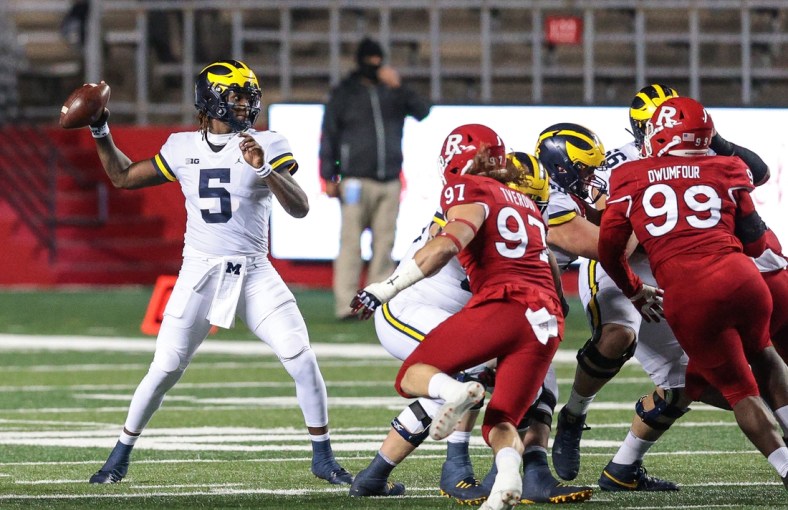 Nov 21, 2020; Piscataway, New Jersey, USA; Michigan Wolverines quarterback Joe Milton (5) throws the ball against Rutgers Scarlet Knights defensive lineman Mike Tverdov (97) and defensive lineman Michael Dwumfour (99) during the first half at SHI Stadium. Mandatory Credit: Vincent Carchietta-USA TODAY Sports