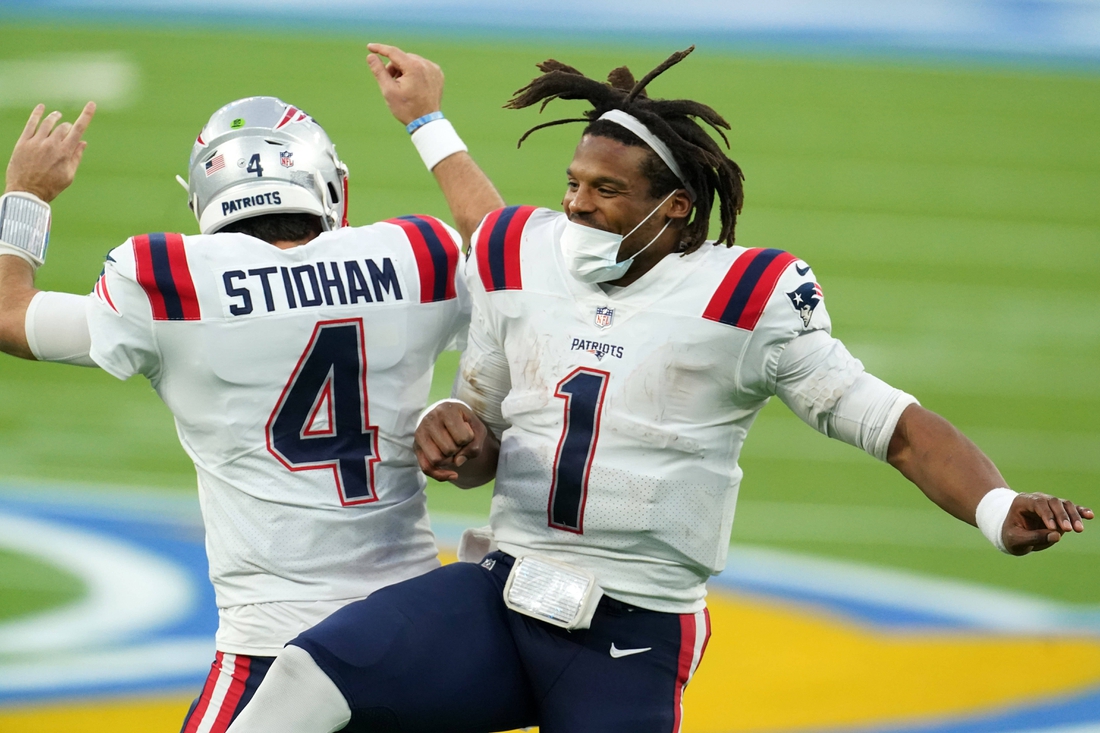 Dec 6, 2020; Inglewood, California, USA; New England Patriots quarterback Cam Newton (1) and quarterback Jarrett Stidham (4) celebrate after a touchdown in the fourth quarter against the Los Angeles Chargers at SoFi Stadium. Mandatory Credit: Kirby Lee-USA TODAY Sports