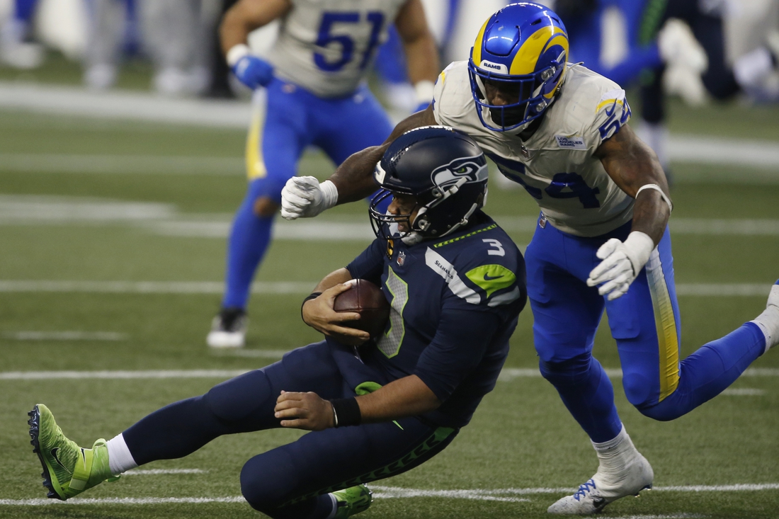 Jan 9, 2021; Seattle, Washington, USA; Seattle Seahawks quarterback Russell Wilson (3) slides after a run while being pursued by Los Angeles Rams linebacker Leonard Floyd (54) during the fourth quarter at Lumen Field. Mandatory Credit: Joe Nicholson-USA TODAY Sports