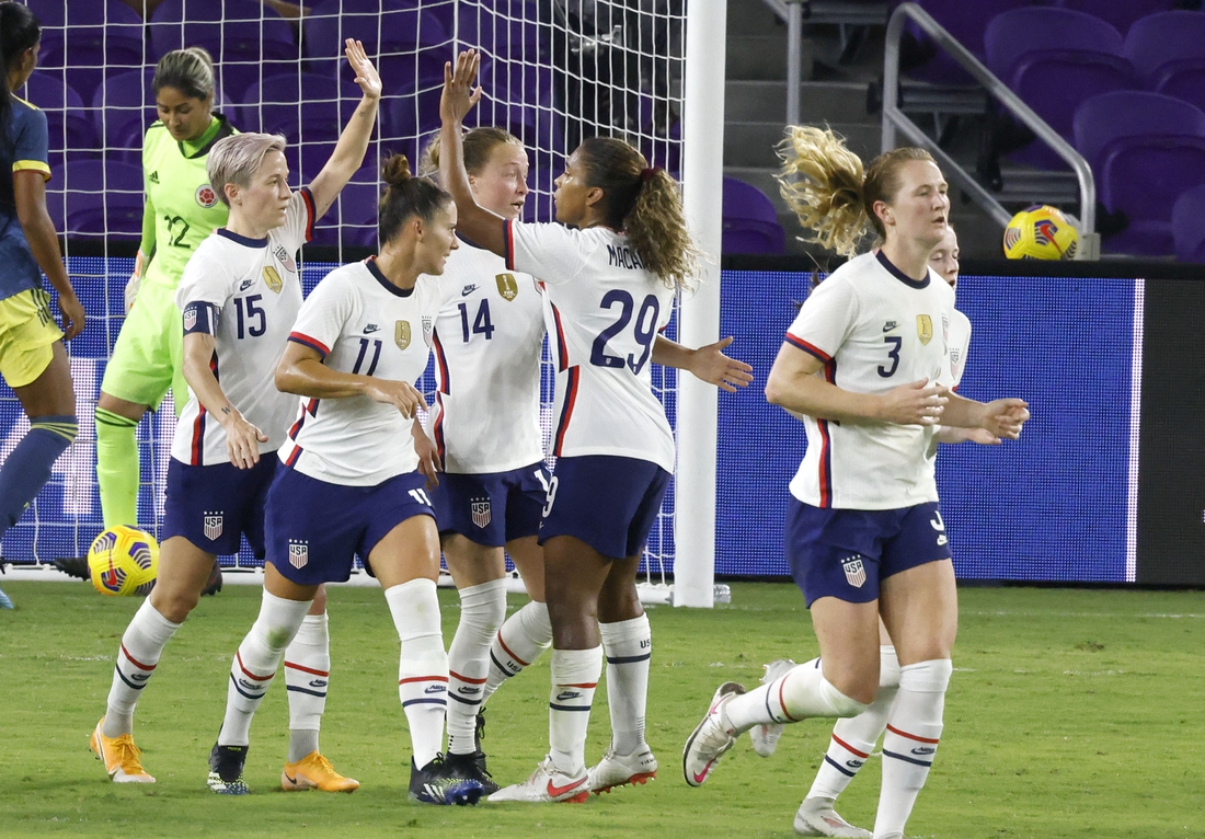 Jan 22, 2021; Orlando, Florida, USA;  the United States forward Megan Rapinoe (15) celebrates her goal with defender Sali Krieger (11) and Emily Sonnett (14) and midfielder Catarina Macario (29) as midfielder Sam Mewis (3) heads back to mid field during the first half against Colombia at Exploria Stadium. Mandatory Credit: Reinhold Matay-USA TODAY Sports