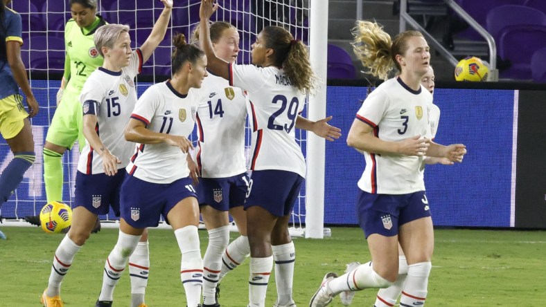 Jan 22, 2021; Orlando, Florida, USA;  the United States forward Megan Rapinoe (15) celebrates her goal with defender Sali Krieger (11) and Emily Sonnett (14) and midfielder Catarina Macario (29) as midfielder Sam Mewis (3) heads back to mid field during the first half against Colombia at Exploria Stadium. Mandatory Credit: Reinhold Matay-USA TODAY Sports