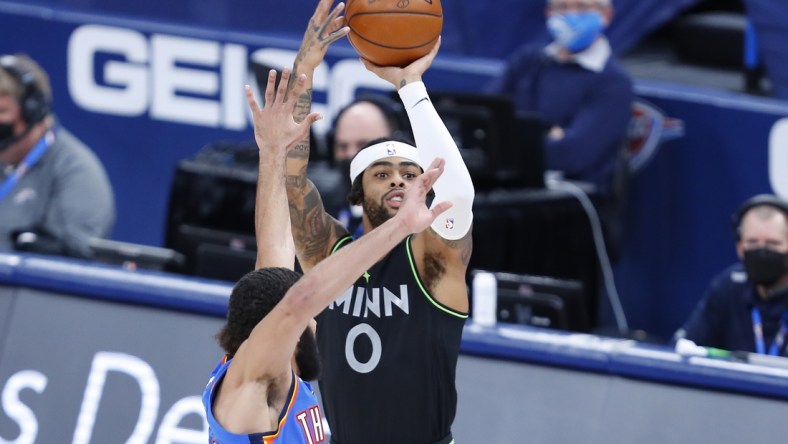 Feb 5, 2021; Oklahoma City, Oklahoma, USA; Minnesota Timberwolves guard D'Angelo Russell (0) shoots as Oklahoma City Thunder guard Kenrich Williams (34) defends during the second half at Chesapeake Energy Arena. Minnesota won 106-103. Mandatory Credit: Alonzo Adams-USA TODAY Sports