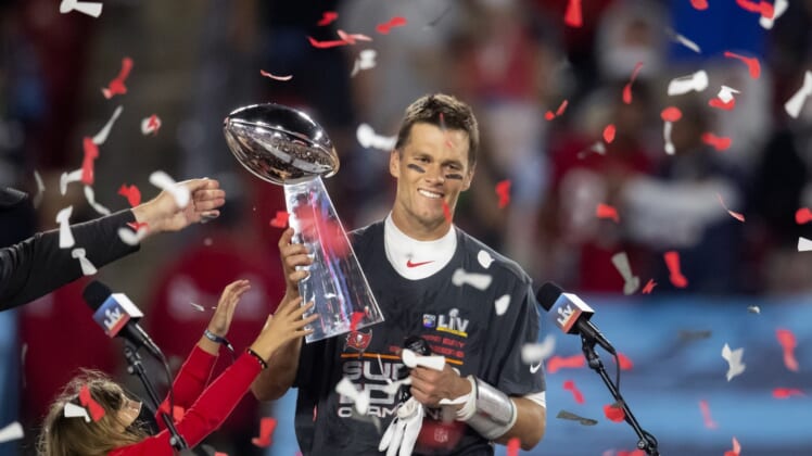 Feb 7, 2021; Tampa, FL, USA;  Confetti falls as Tampa Bay Buccaneers quarterback Tom Brady (12) celebrates with the Vince Lombardi Trophy after beating the Kansas City Chiefs in Super Bowl LV at Raymond James Stadium.  Mandatory Credit: Mark J. Rebilas-USA TODAY Sports