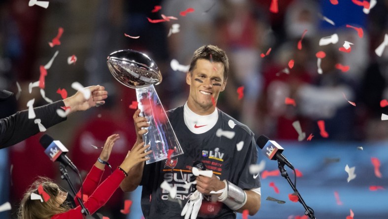 Feb 7, 2021; Tampa, FL, USA;  Confetti falls as Tampa Bay Buccaneers quarterback Tom Brady (12) celebrates with the Vince Lombardi Trophy after beating the Kansas City Chiefs in Super Bowl LV at Raymond James Stadium.  Mandatory Credit: Mark J. Rebilas-USA TODAY Sports