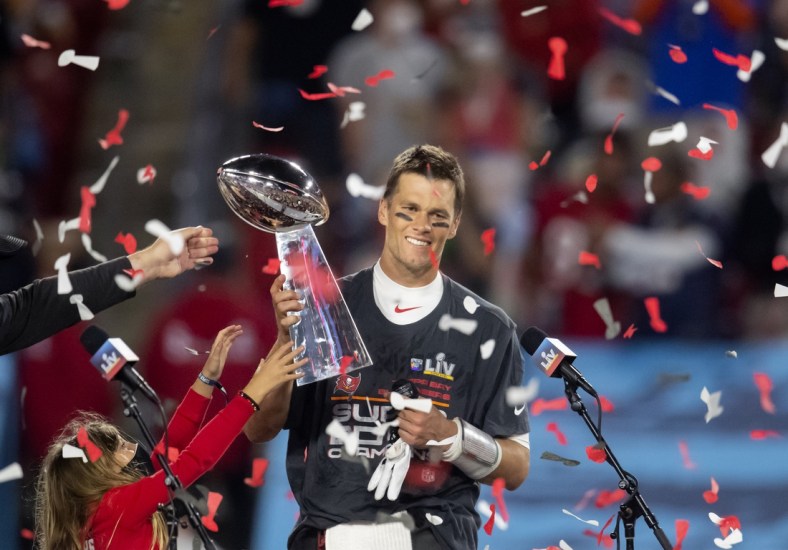 Feb 7, 2021; Tampa, FL, USA;  Confetti falls as Tampa Bay Buccaneers quarterback Tom Brady (12) celebrates with the Vince Lombardi Trophy after beating the Kansas City Chiefs in Super Bowl LV at Raymond James Stadium.  Mandatory Credit: Mark J. Rebilas-USA TODAY Sports
